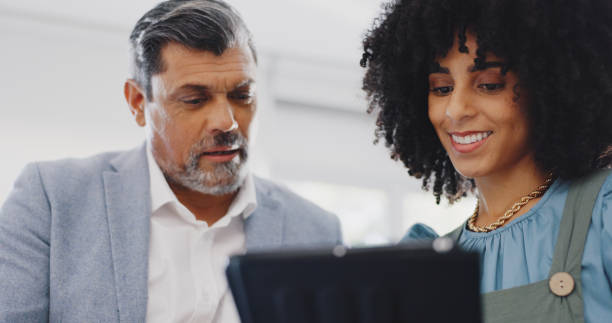 istock Business people, smile and planning with a tablet, teamwork and project with research, data analysis and schedule. Coaching, man and woman with technology, digital app and cooperation in a workplace 1779632266