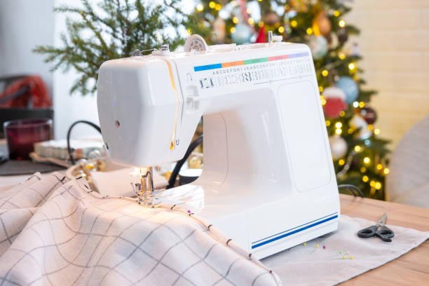 istock Sewing process on a sewing machine, a needle with a thread and a holder close-up stitch the white checkered fabric. Preparation for Christmas and new year, textiles for cozy in festive decor interior 1779637373
