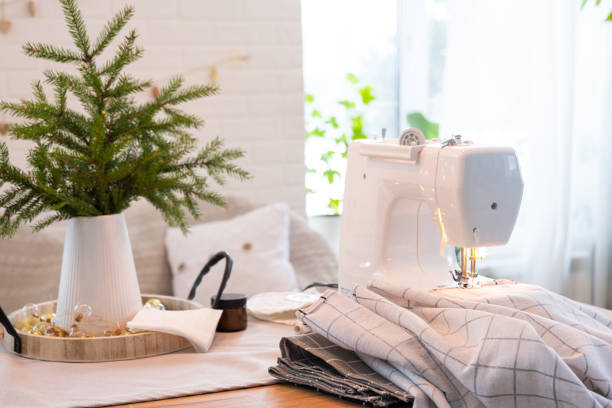 istock Sewing process on a sewing machine, a needle with a thread and a holder close-up stitch the white checkered fabric. Preparation for Christmas and new year, textiles for cozy in festive decor interior 1779637379