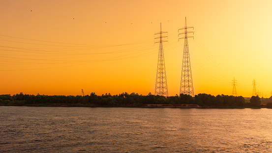 Power lines on bank of the River Nile at sunset