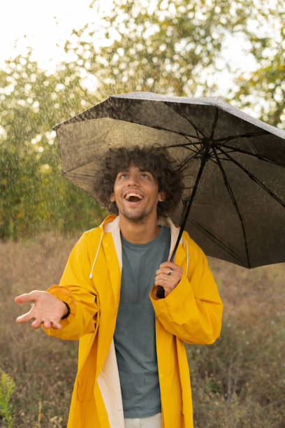 istock Handsome arabic man holding umbrella while strolling outside. He is looking at camera with true delight and sincere smile. 1779656832
