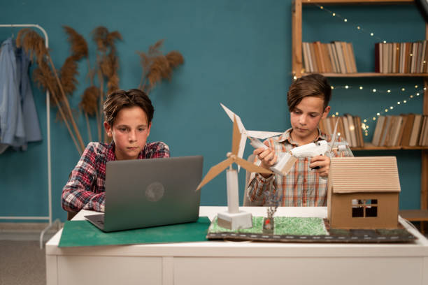 istock Group of school student learning and discussing about renewable energy science with windmill turbines model, student learning about sustainable energy. 1779660689