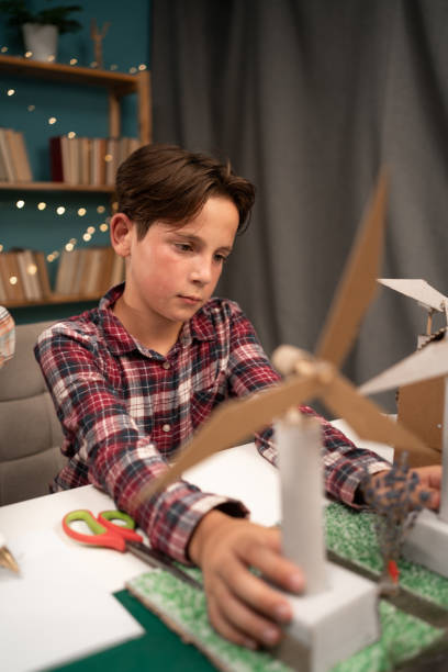 istock Schoolboy work with wind turbine prototype, learning about environment and renewable energy at home 1779661212
