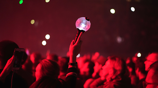 Bts k pop band fan raise hand up hold bomb light stick lamp. Fun korean people enjoy kpop live music concert. Crowd hang out cool night show. Asian idols army wave red flash light. Joy party fest tour