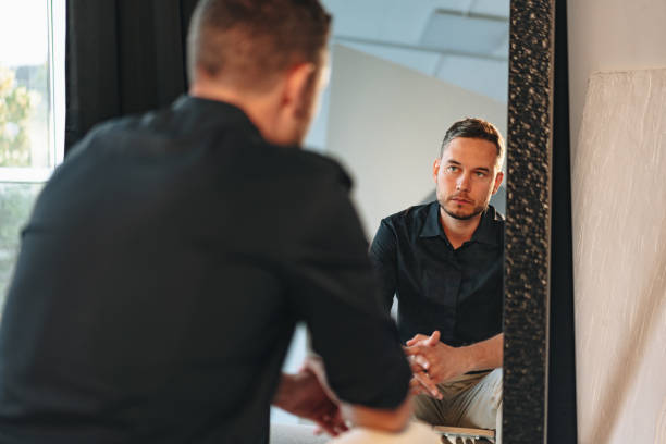 istock Young man looking at himself in the mirror 1779686013