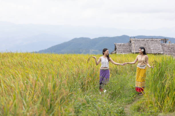 Laotian mom with her little boys, wearing traditional Lantan tribe clothes, walking together in a Lantan village in Northern Laos