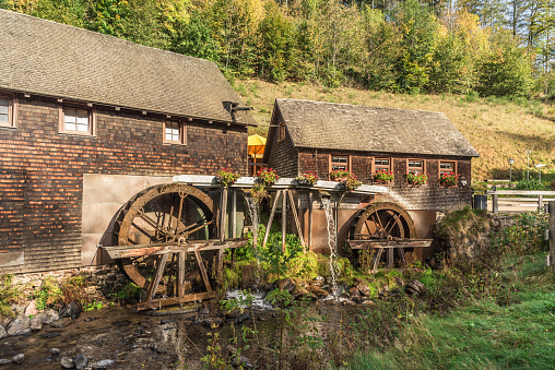 Furtwangen, Baden-Württemberg, Germany - October 17, 2013. Traditional mill with two water wheels in the Black Forest near Furtwangen. The Hexenloch Watermill (german: Hexenlochmühle) was built in 1825 and is one of the most famous historic water mills in the Black Forest. It is the only mill in the Black Forest that is driven by two water wheels.