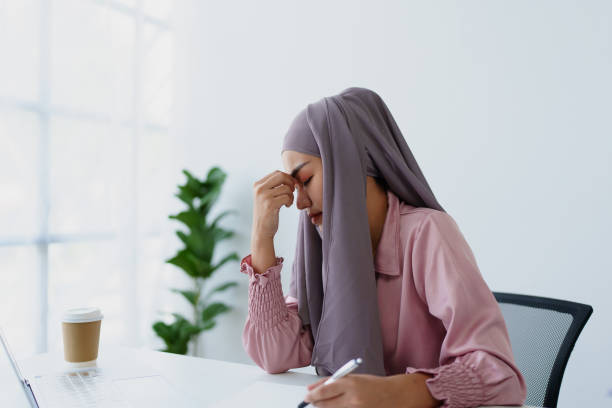 Muslim female employee working in office burnout.