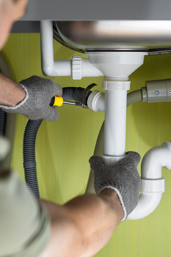 Repairing a pipe in the kitchen under the sink. kitchen plumbing repairs. connecting the washing machine drain. fix water plumbing leaks, replace the kitchen sink drain, cleaning clogged pipes is dirty or rusty.