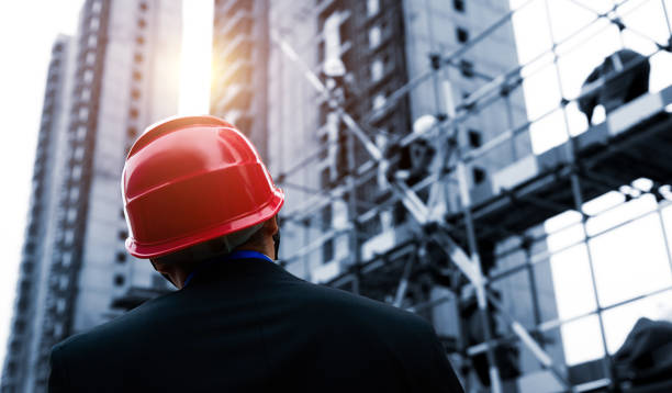 Rear view of builder inspector at construction site