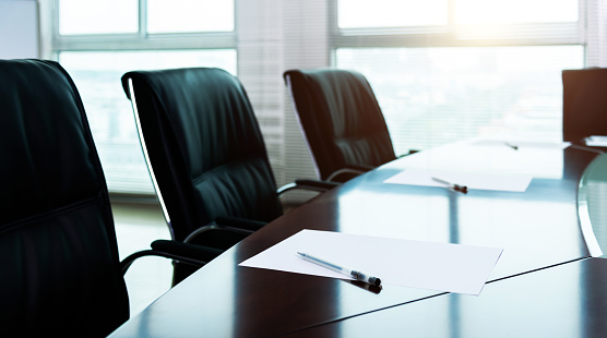 Group of diverse businesspeople talking together around a conference table during a boardroom meeting in a modern office