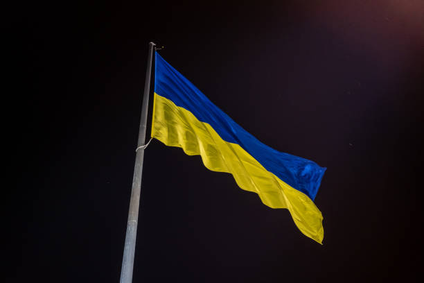 istock Ukrainian national official flag blowing on night sky background 1779745726