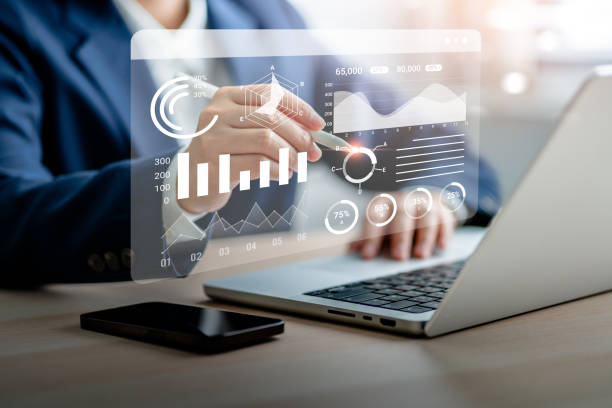 istock Businesswomen analyze chart data business on a visual screen dashboard laptop, technology devices and screens visible in the background, financial planning, market research, and the stock market. 1779764393