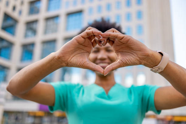 istock Happy beautiful nurse smiling through heart shape she has made with her hands 1779770634