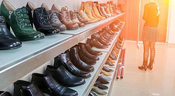 Shelves with shoe samples in a shoe factory. Bright big shoe store with a new collection.