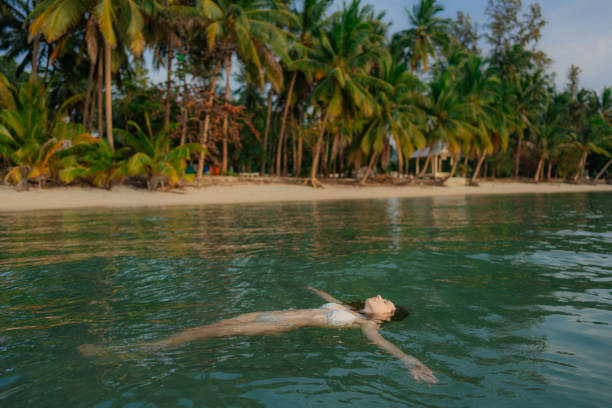 Young Woman in white swimwear swimming in the sea on Ko Samui