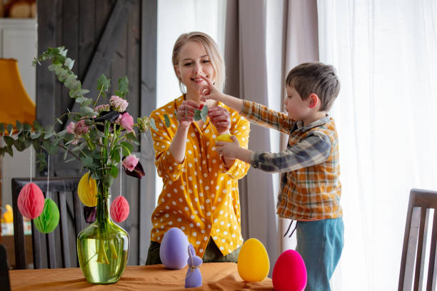 istock mother and son are decorating a table with paper eggs for Easter. Indoor 1779804195