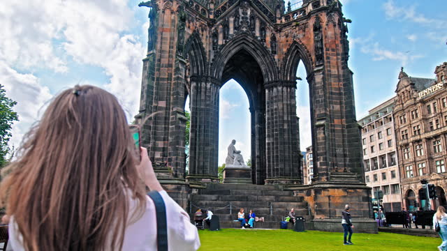 Female tourist visiting Scott Monument in Edinburgh, Scotland.