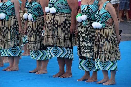 A group of New Zealand Maori folk dancers performing in an outdoor festival.