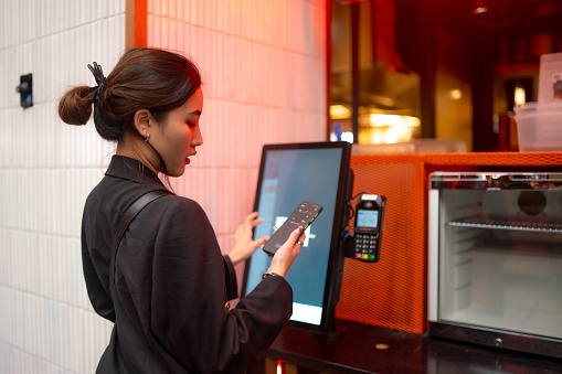 A young female ordering on a self service kiosk