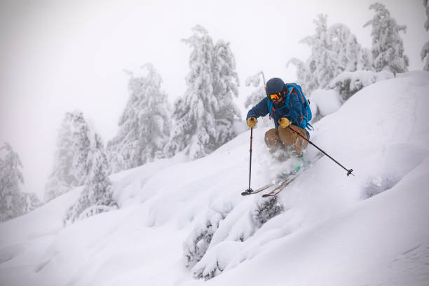 joven esquiador de travesía fuera de pista en nieve profunda - freeride fotografías e imágenes de stock