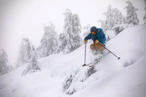 Photo of Young back country skier riding off-piste in deep snow