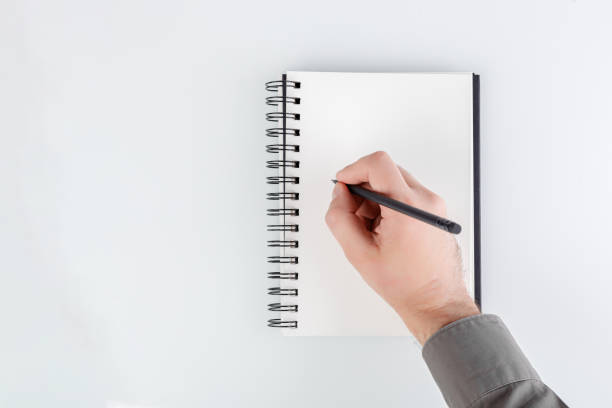 istock business notepad, hand holding a pencil on a white background 1779844326