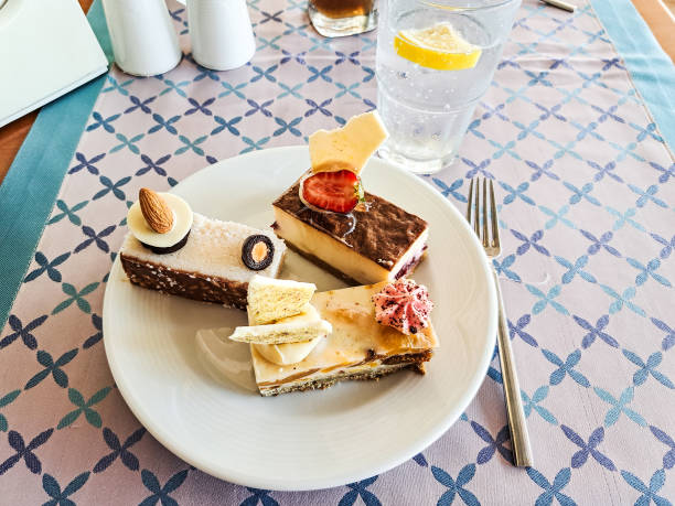 A plate with cakes and dessert tarts stands on a table