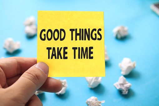 Good things take time, text words typography written on paper against blue background, life and business motivational inspirational concept