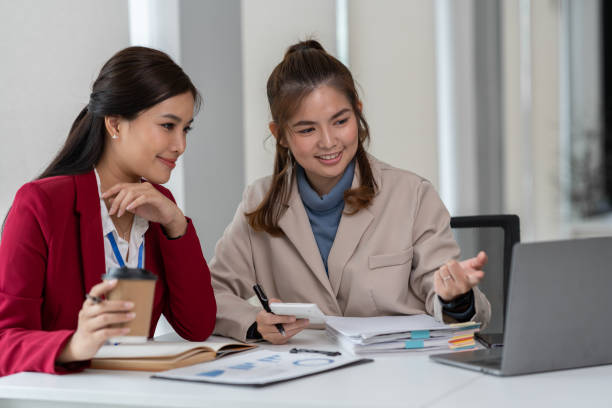 istock team work process Two asian businesswoman working with laptop computer and discussing documents project idea presentation Analyze the marketing plan. Investment in the office 1779873257