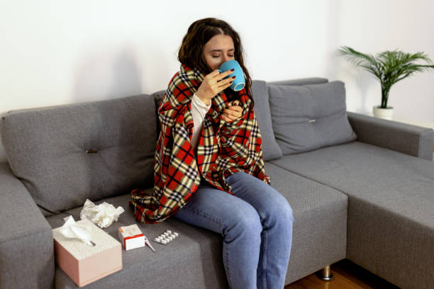 istock Ill woman with cold temperature drinking herbal tea at home 1779878417