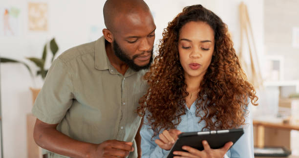 istock Teamwork, business people and working on tablet planning, collaboration or SEO analytics in office. Tech, employees and manager consulting with employee on research, web design and data analysis 1779902524