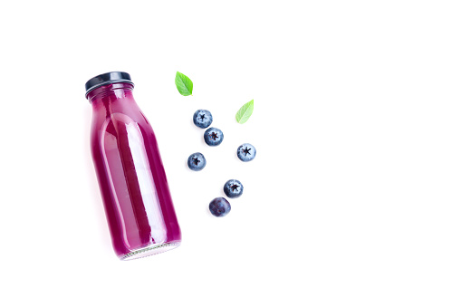 Blueberry juice in glass bottle with ripe blueberry fruits and green leaves isolated on white background, Fresh Fruit, Healthy Fruit, Healthy Drink