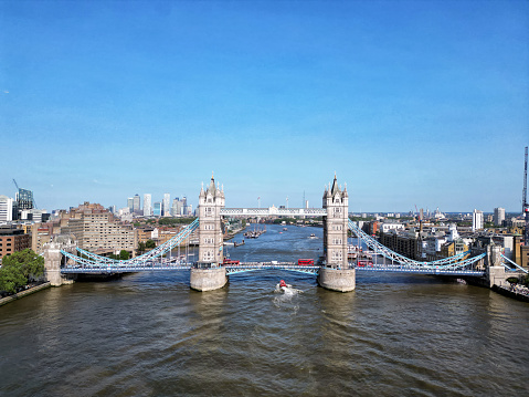 Panoramic aerial view of the skyline of London with the lifted Tower Bridge and a cruise ship passing under