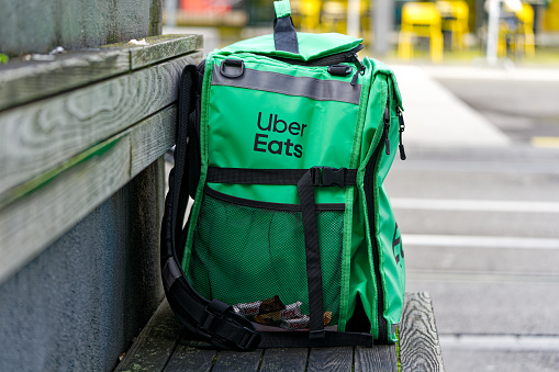 Green and black bag of Uber Eat courier at Swiss City of Zürich on a cloudy autumn day. Photo taken October 27th, 2023, Zurich, Switzerland.
