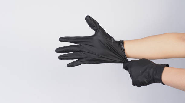 istock Hand is pulling black latex gloves on white background. 1779928924
