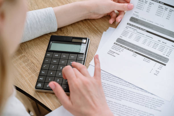 istock female holding utility bill and counting monthly expense on calculator 1779938830