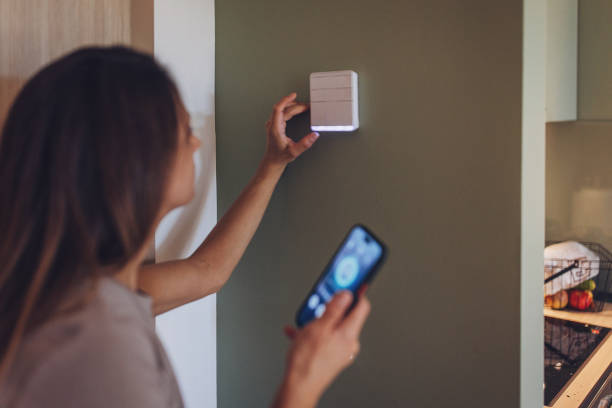 istock Woman using smart phone to control the smart home 1779970542