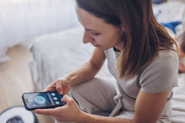 istock Woman using smart phone to control the smart home 1779972327