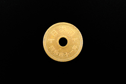 Macao 1 pataca coin isolated on black background.
