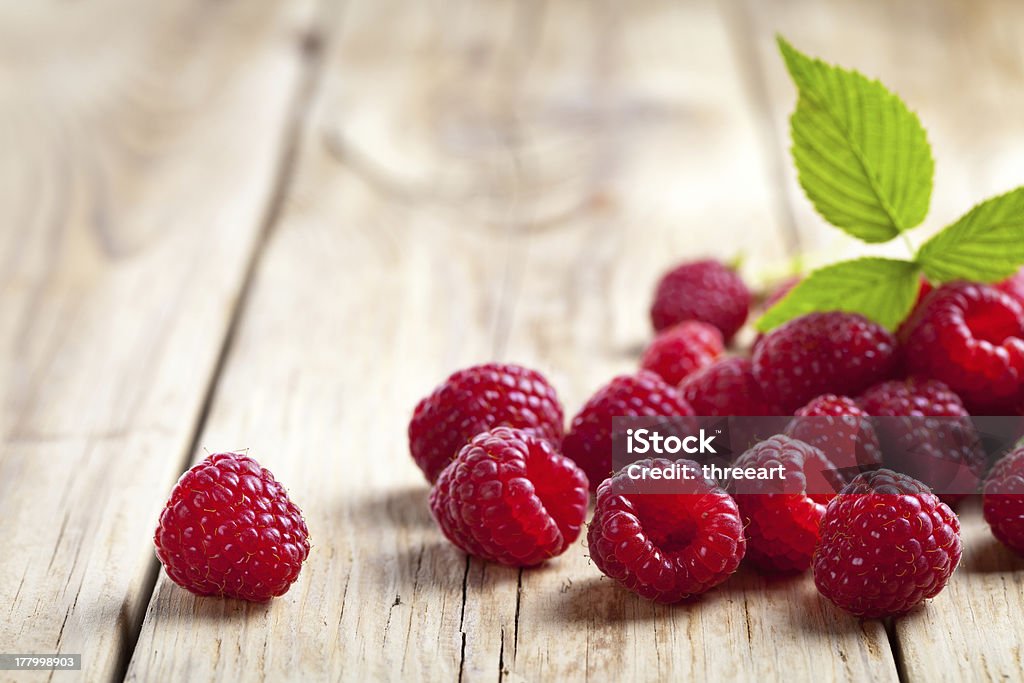 Raspberries Raspberries with leaf on wooden table background. Copy space Berry Fruit Stock Photo