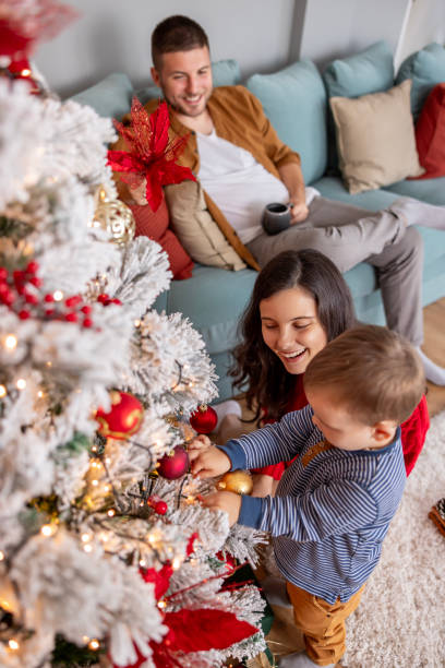 istock Parents decorating Christmas tree with their little son 1779998976