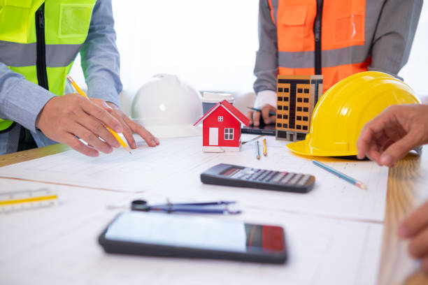 istock Architects and construction engineers meet to discuss blueprints of building structures in order to calculate the completion of the construction project. Real estate construction business concept. 1780032039