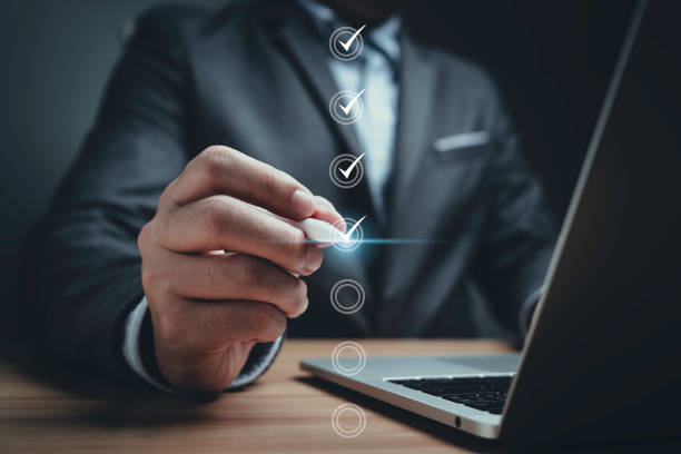 istock Businessman using electronic pen to tick correct sign mark in online document checklist for quality control assurance of ISO concept. 1780035713