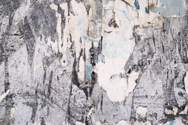 istock Torn and peeled old white paper on the street wall 1780049342