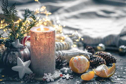 Cozy Christmas composition with a burning candle and decorative details, winter mood, holiday decoration, magic Christmas, copy space.