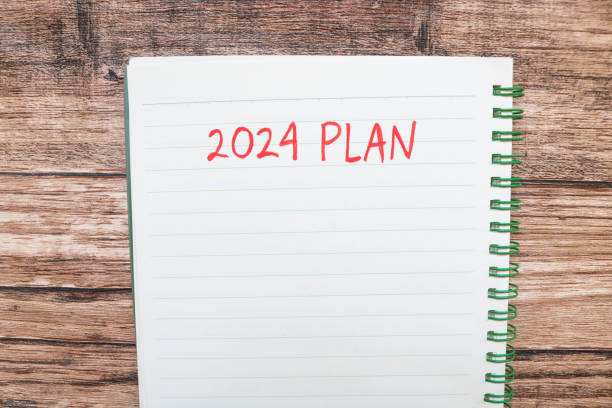 istock New year's resolutions 2024 on the table. 2024 plan writing with notebook on wooden table. New Year 2024 Theme 1780062475