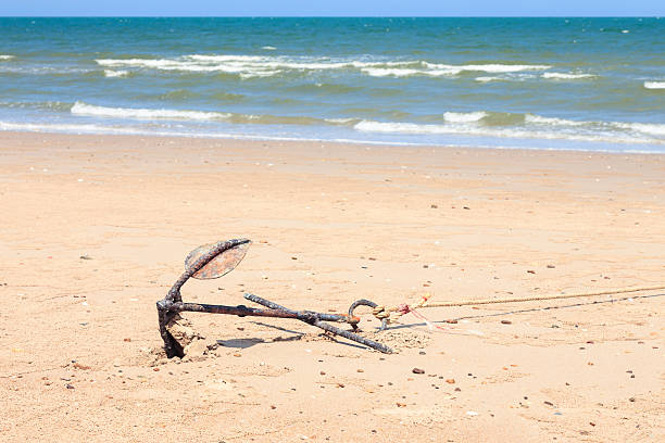 istock Small rusty traditional anchor on a beach by the sea 178006627