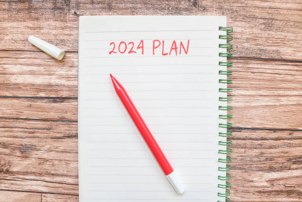 istock New year's resolutions 2024 on the table. 2024 plan writing with notebook and colorful markers on wooden table. New Year 2024 Theme 1780067997