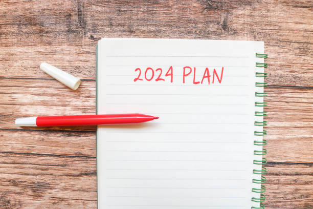 istock New year's resolutions 2024 on the table. 2024 plan writing with notebook and colorful markers on wooden table. New Year 2024 Theme 1780068557